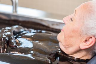  Elderly woman in mud bath